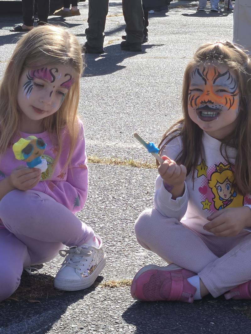 Two children with festive face paint at a church event