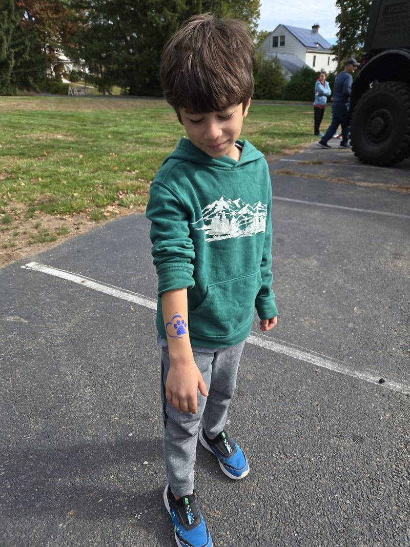 A child showing off a glitter paw-print tattoo at a church event